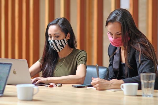 Women working while wearing masks