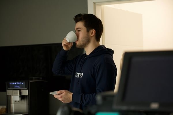 A man drinking coffee while standing