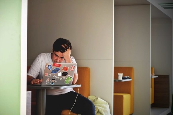 Man holding his head while working