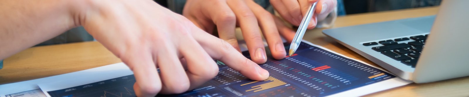 Hands pointing at business chart on a table