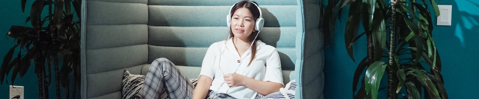 Woman listening to music in office chill out area and recovering from work